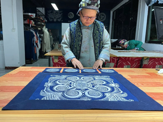 Miao batik artisan drawing wax-resist patterns on cloth
