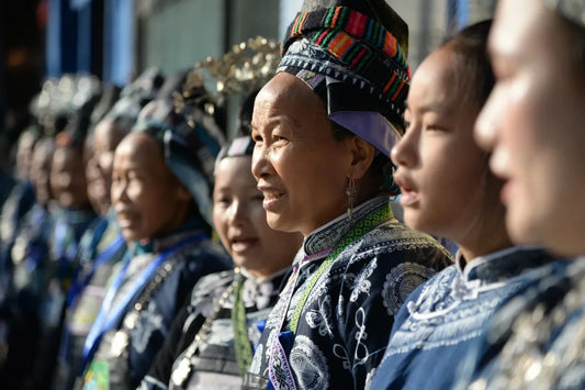 Women in traditional Miao dress standing together during a community gathering in Guizhou