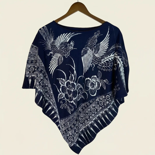 Miao batik poncho with white floral and bird patterns on a beige background