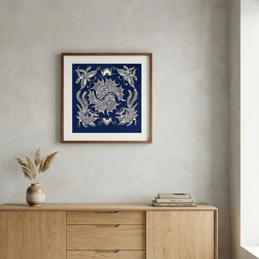 Framed Miao batik artwork of a dragon design on a wall above a wooden cabinet.