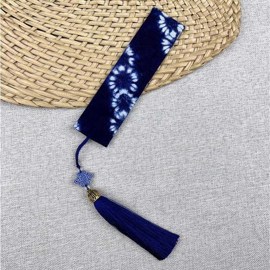 Blue tie-dye Bookmark with tassel on a textured surface