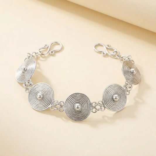 Miao Silver bracelet with circular designs on a beige background