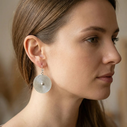 Close-up of a woman wearing a miao silver earring with a blurred background