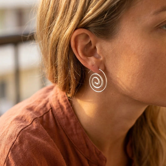 Miao Silver Spiral Stud Earrings worn for scale