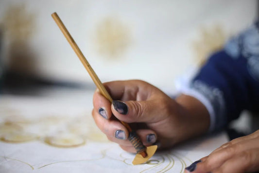 Using a batik wax knife to draw Miao batik wax-resist lines