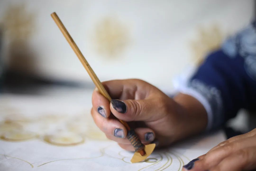 Using a batik wax knife to draw Miao batik wax-resist lines