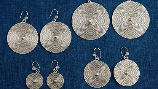 Collection of handmade Miao silver statement jewelry pieces on natural background 16:9 banner