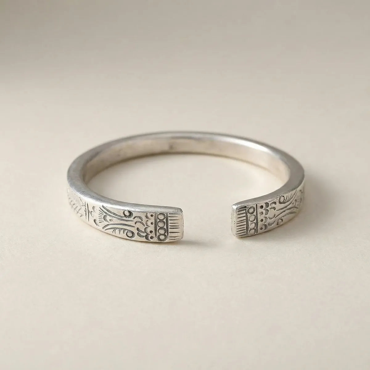 Miao Silver ring with intricate designs on a beige background