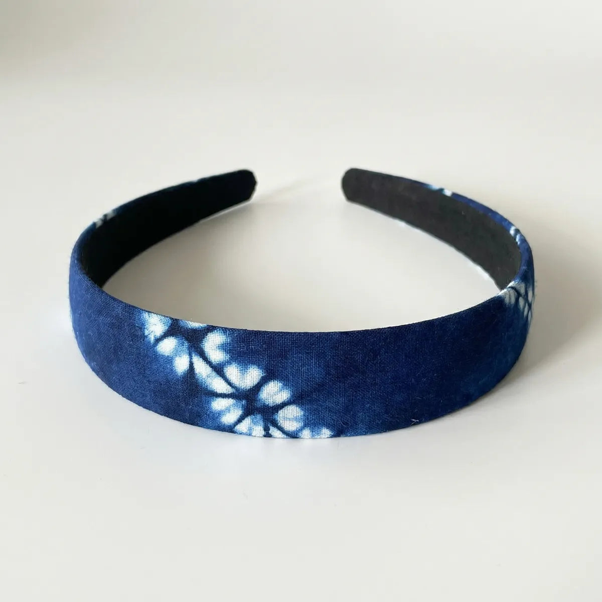 Blue tie-dye headband on a white background