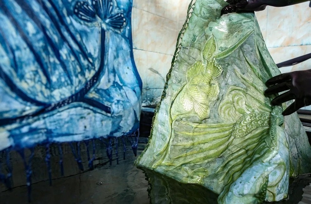 Tissu batik ciré immergé dans la teinture indigo pendant l'oxydation
