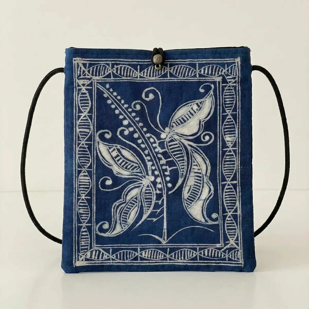Miao batik drawstring bag with white butterfly design on a light background