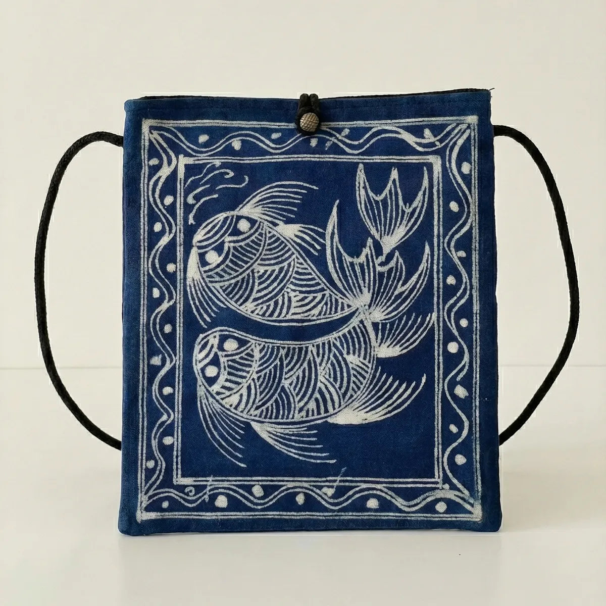 Miao batik drawstring bag with white fish design on a light background