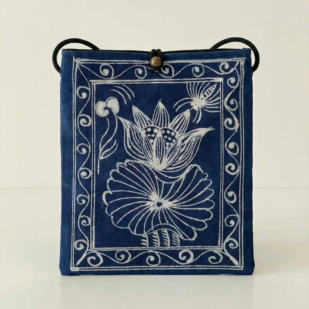 Miao batik crossbody bag with white floral design on a light background