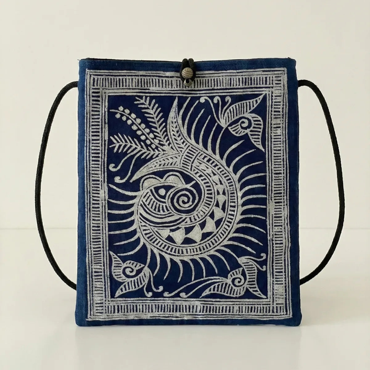 Miao batik drawstring bag with white floral pattern on a white background