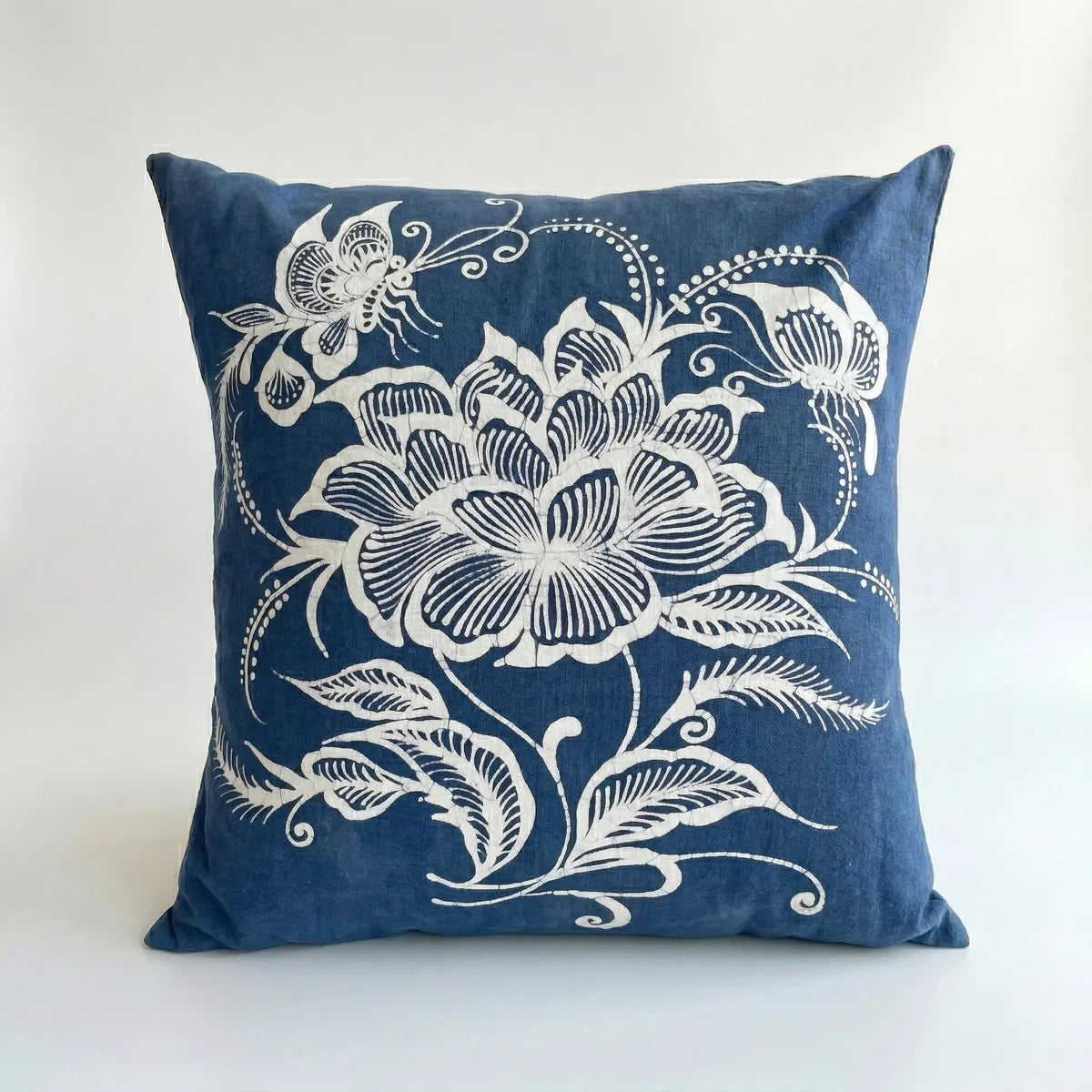 miao batik pillow with white floral and butterfly design on a white background