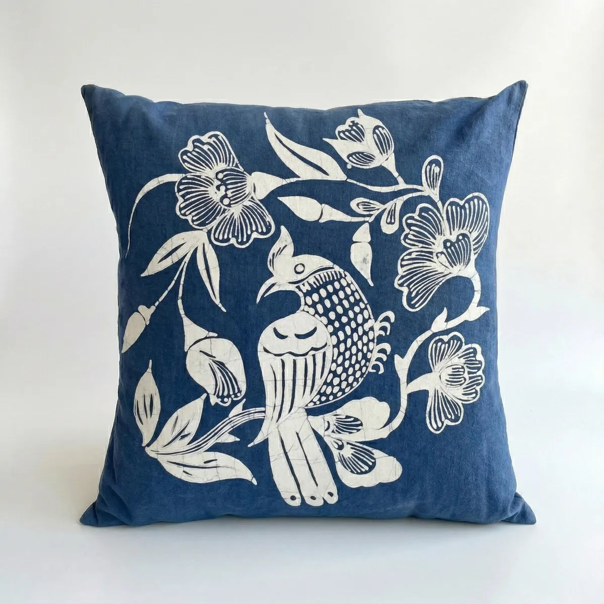 Miao batik pillow with white floral and bird design on a white background