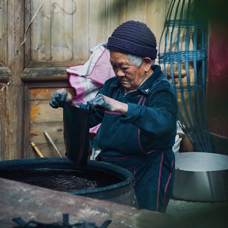 Miao batik process showing wax drawing and indigo dyeing