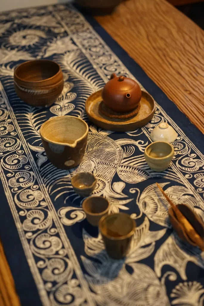 Tea set styled on a Miao batik table runner with indigo and white patterns