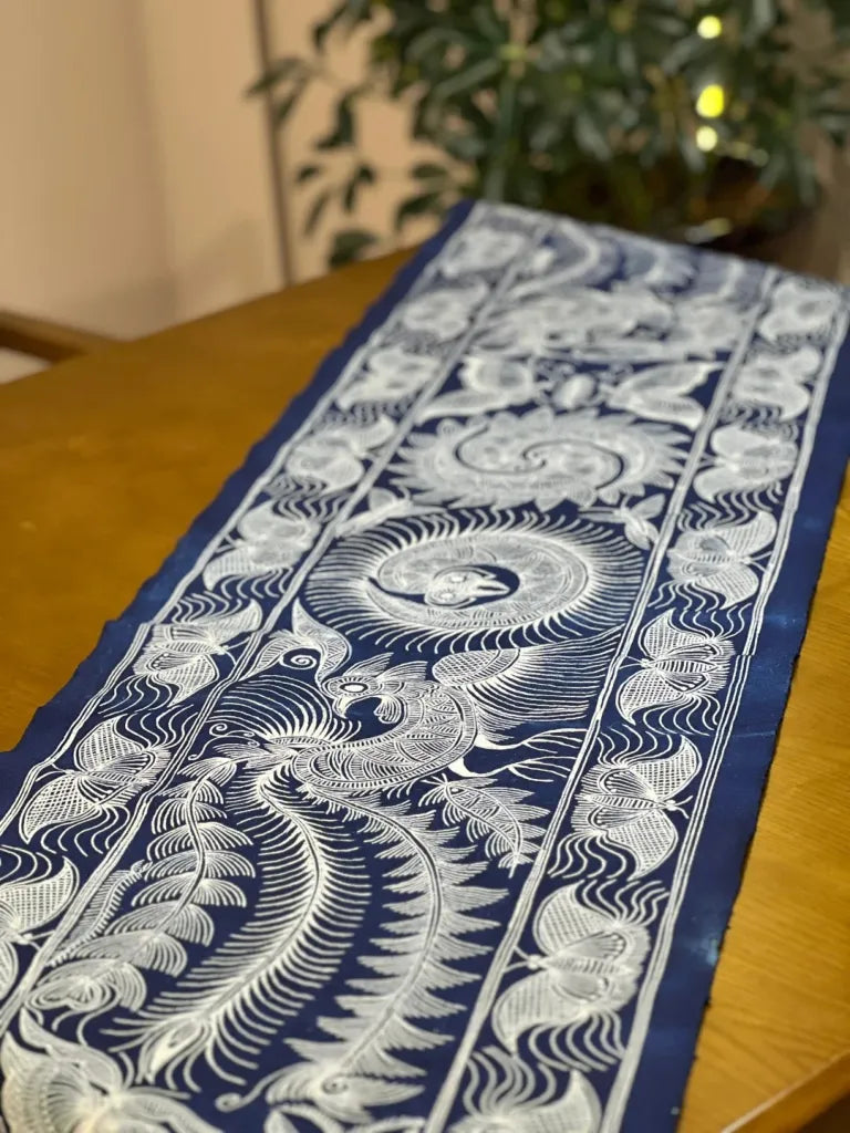Miao batik table runner styled on a wooden table with indigo textile patterns