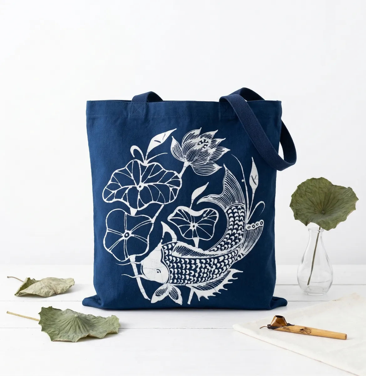 Navy blue Miao batik tote bag with white fish and floral design on a white background