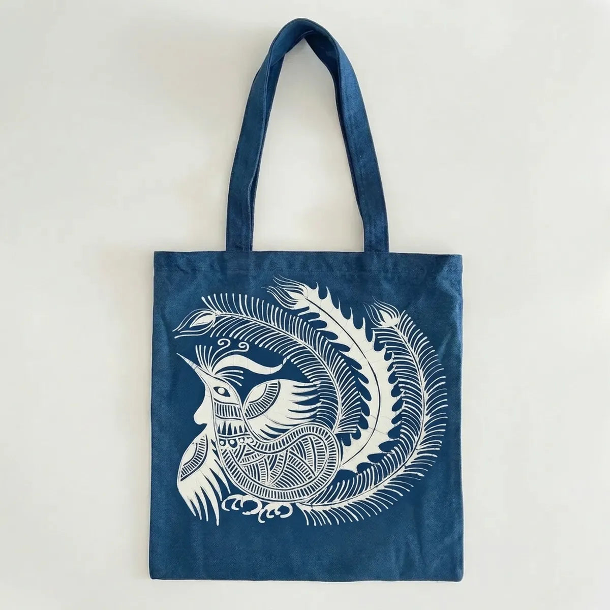 Miao batik  tote bag with white feathered creature design on a light gray background