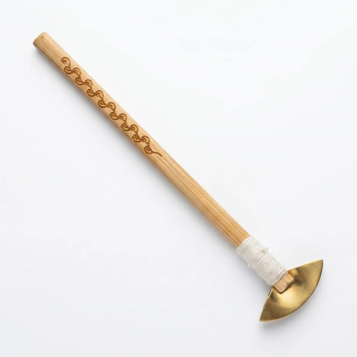 Wooden Miao Batik wax knife with a white handle and brass head on a light gray background