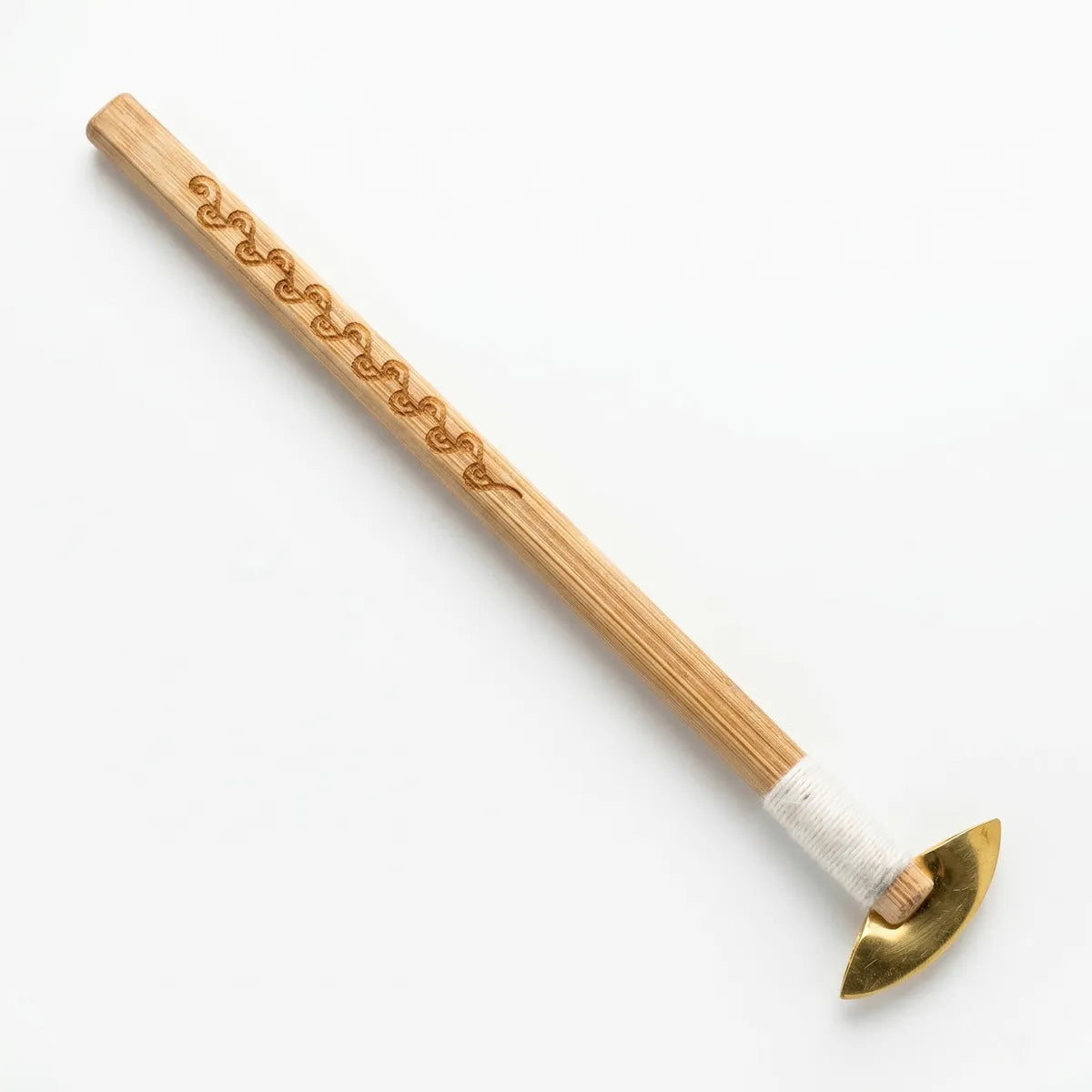 Wooden Batik tool with decorative carvings and a brass head on a white background
