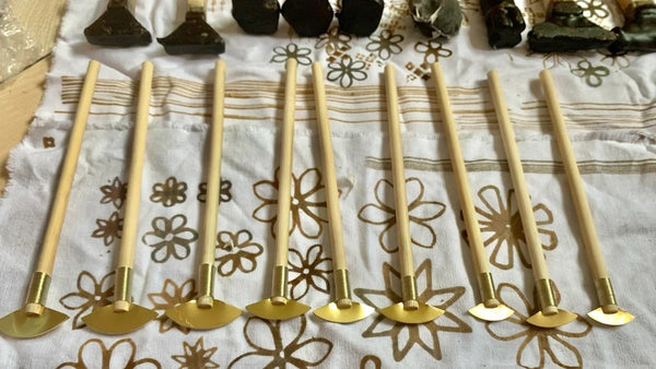Miao batik wax tool placed on indigo patterned fabric