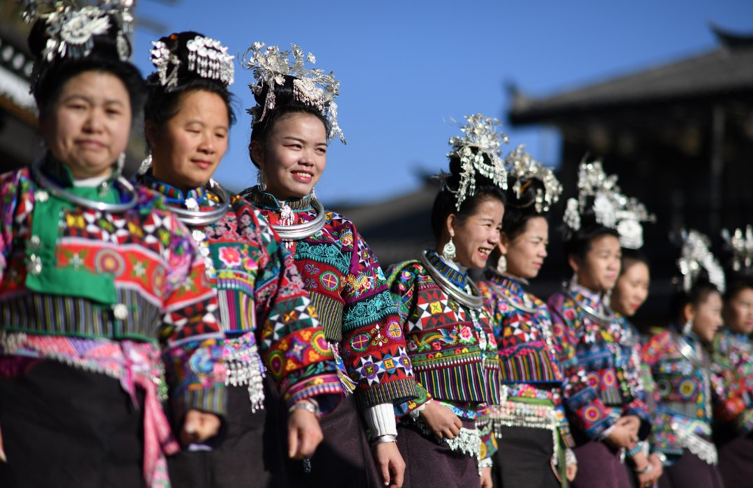 Miao women in traditional dress showing batik, embroidery, and silver accessories