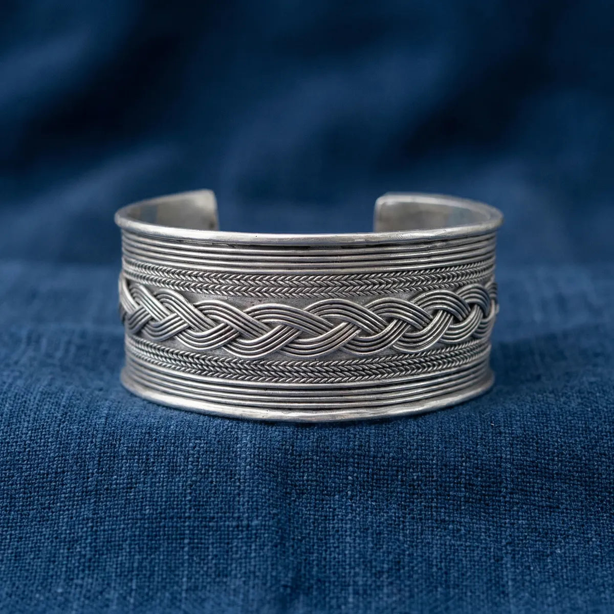 Miao Silver bracelet with braided design on a blue fabric background