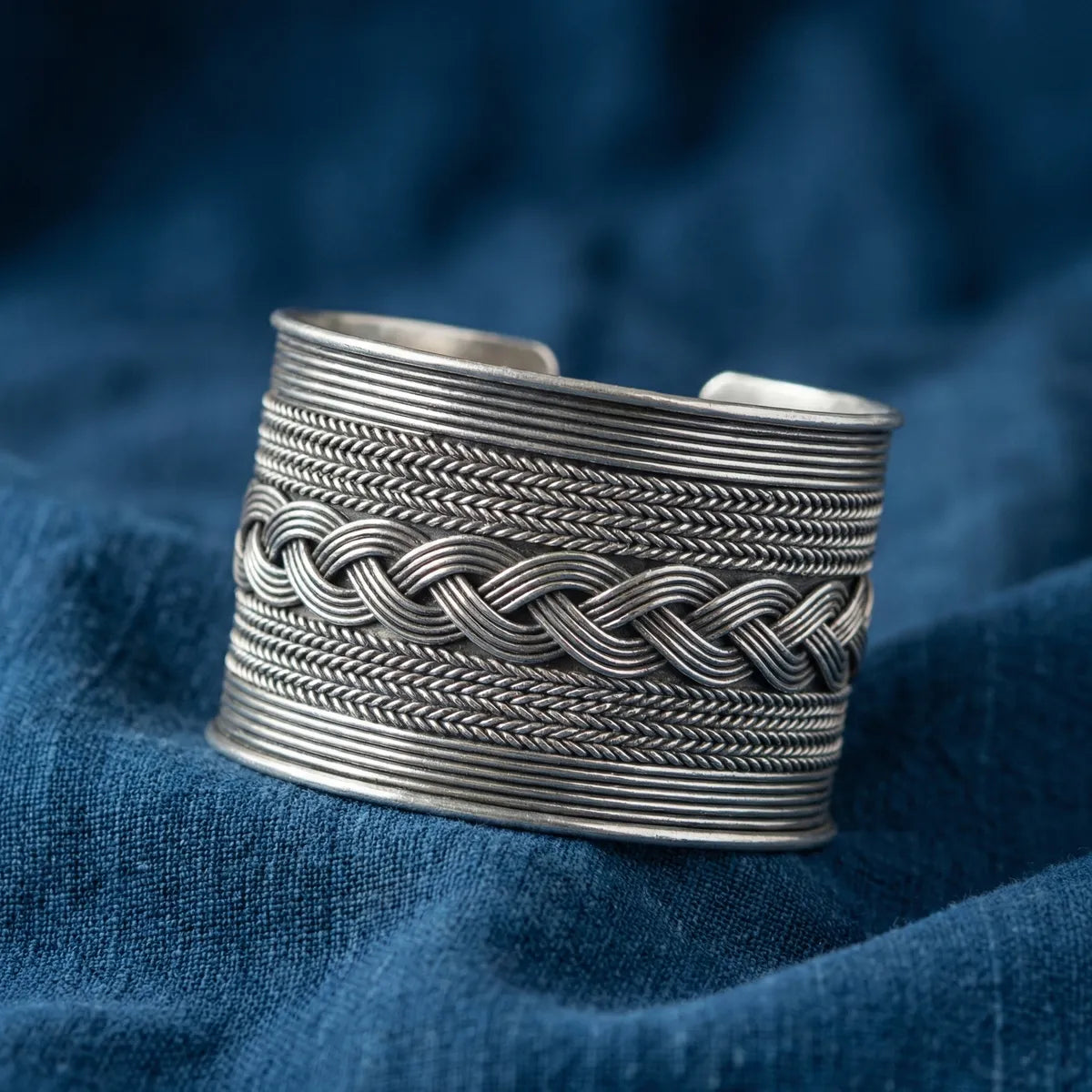 Miao Silver bracelet with braided design on a blue fabric background