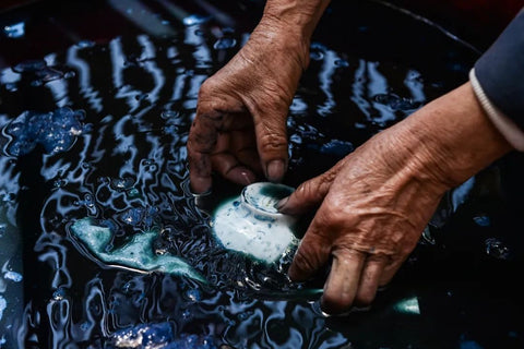 Hands working with indigo-dyed Miao batik textile