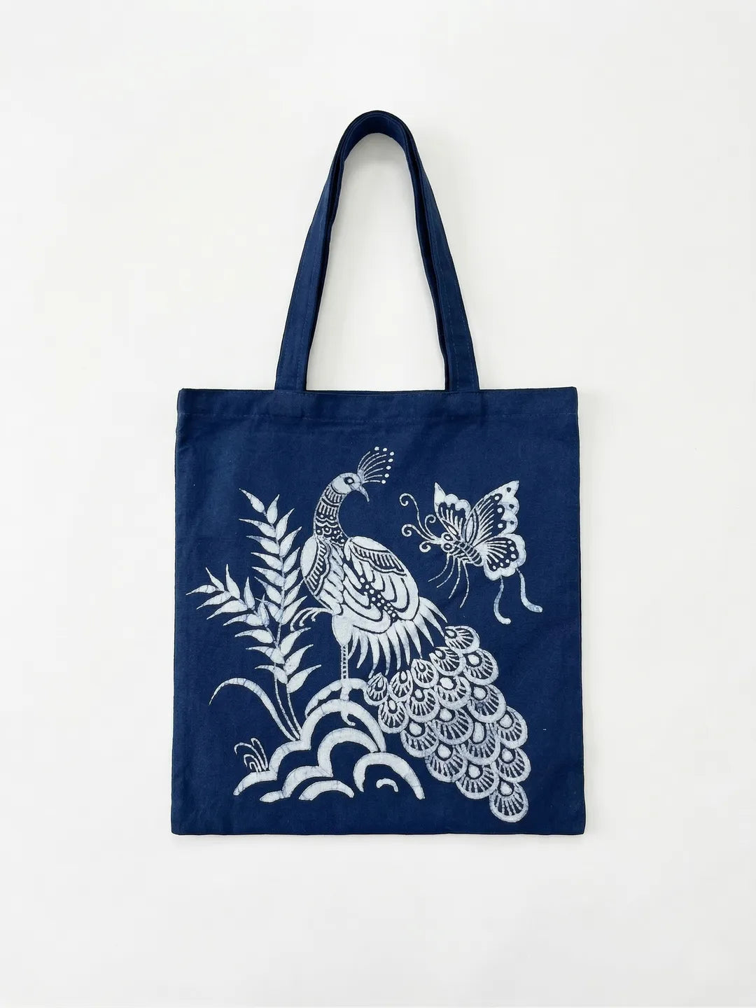 Navy Miaozu Batik tote bag with white peacock and butterfly design on a white background