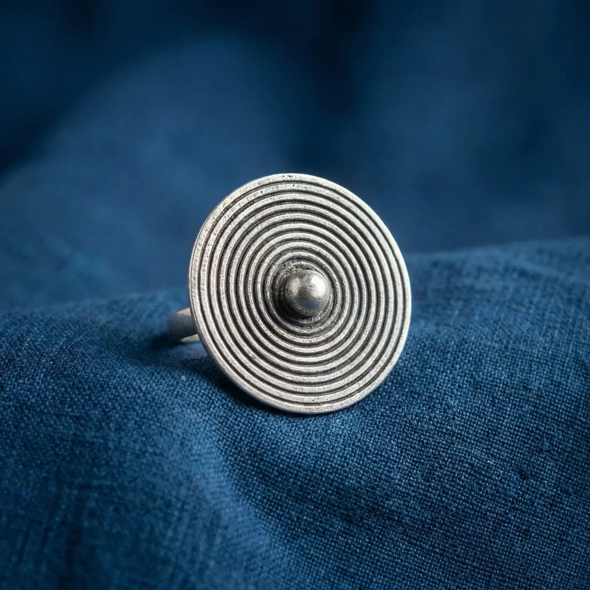 Miao Silver ring with concentric circles on a blue fabric background