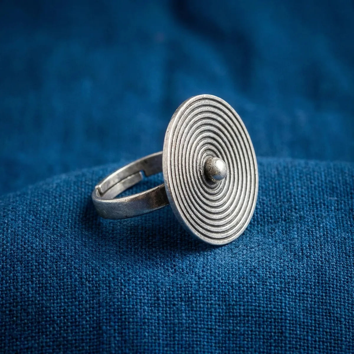 Miao Silver ring with circular design on a blue fabric background