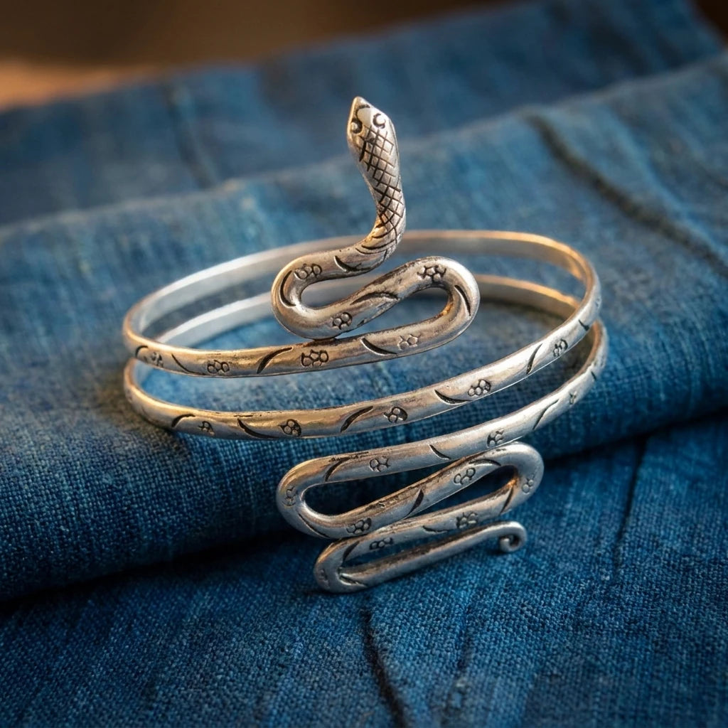 Miao Silver Coiled Snake Arm Cuff displayed on indigo textile