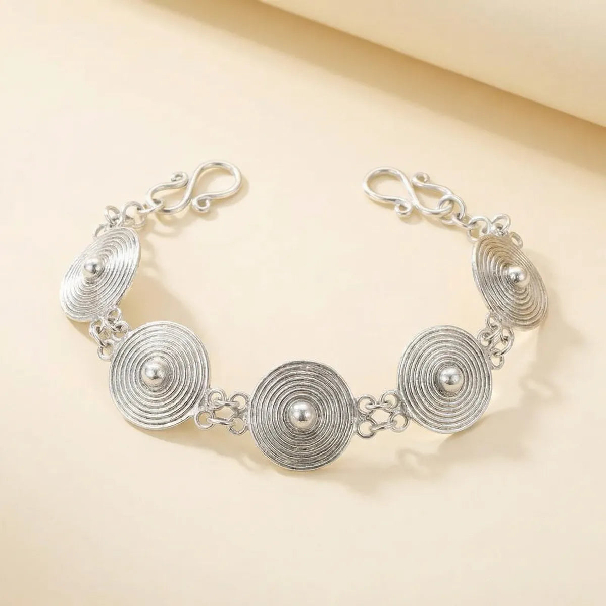 Miao Silver bracelet with circular designs on a beige background