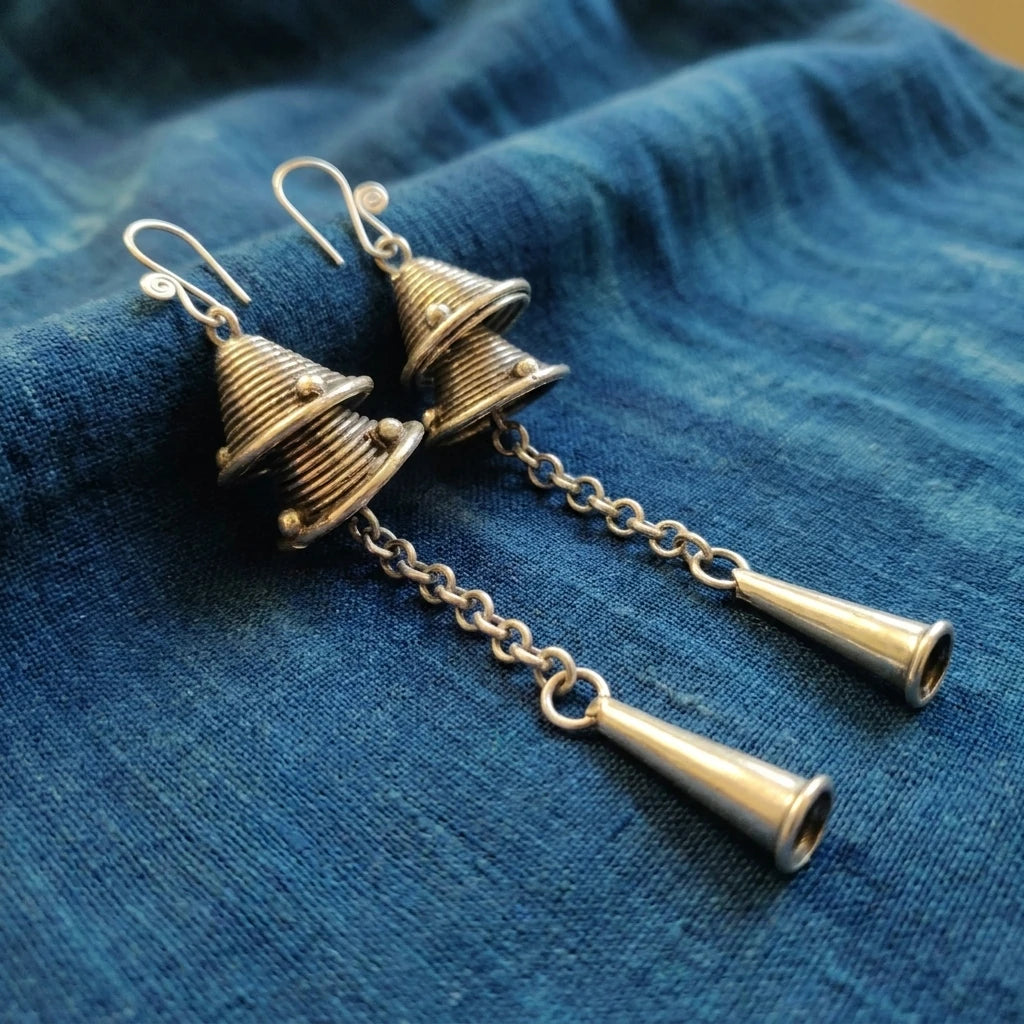 Miao Silver Double Bell Dangle Earrings – Long Tassel Bell displayed on indigo textile