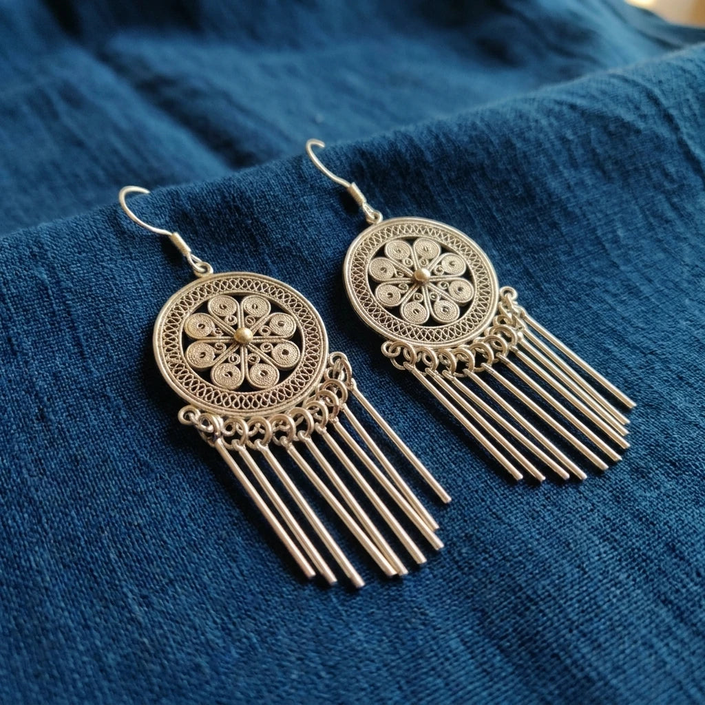 Miao Silver Filigree Tassel Earrings displayed on indigo textile