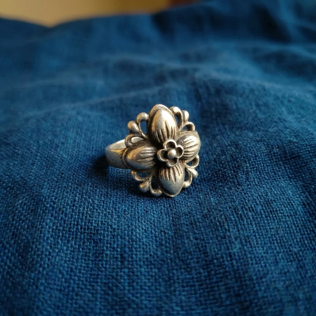 Miao Silver Floral Adjustable Ring displayed on indigo textile