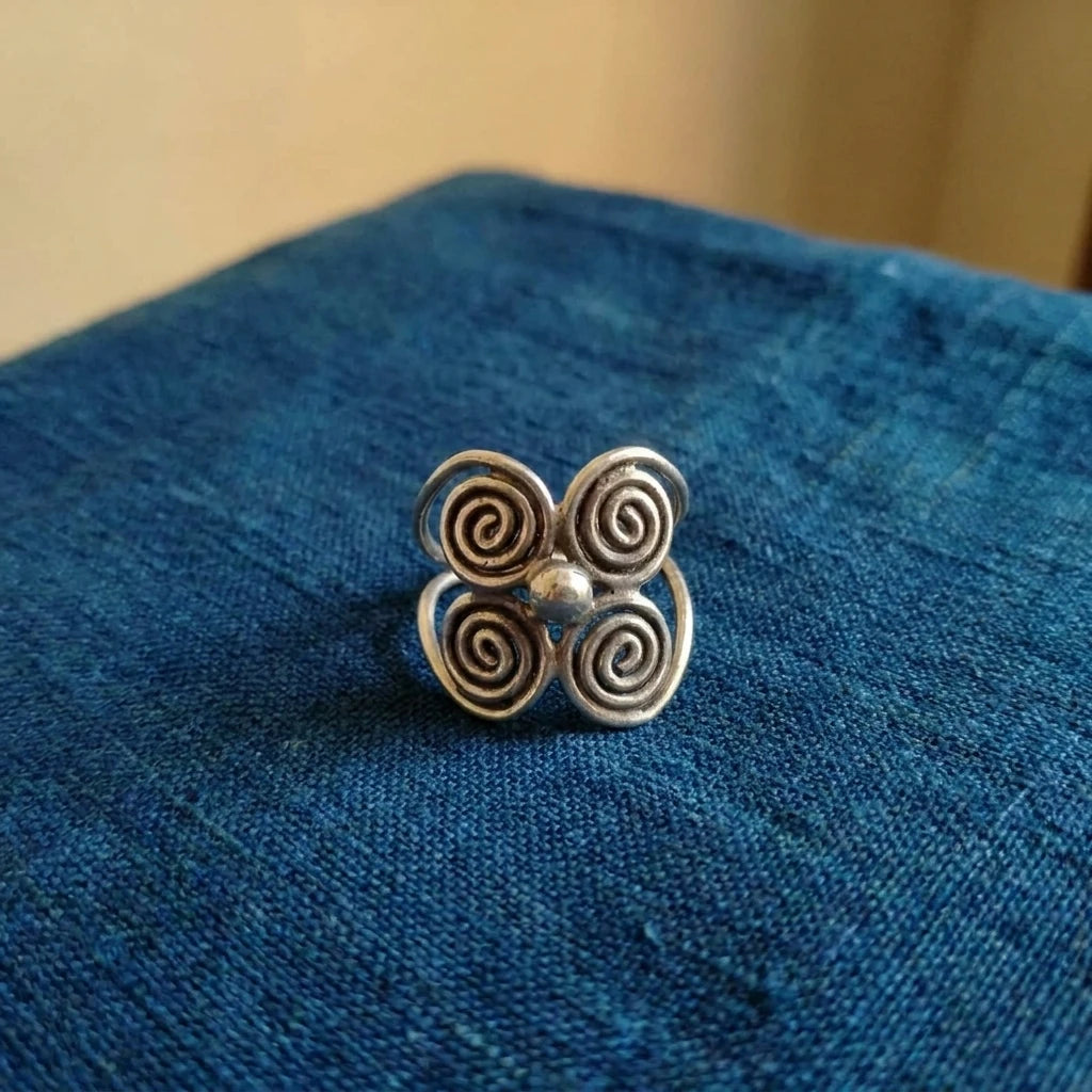 Miao Silver Four-Spiral Adjustable Ring displayed on indigo textile