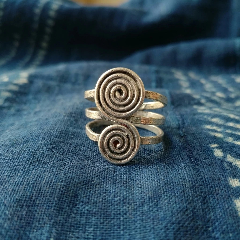Miao Silver Linked Spiral Disc Ring displayed on indigo textile