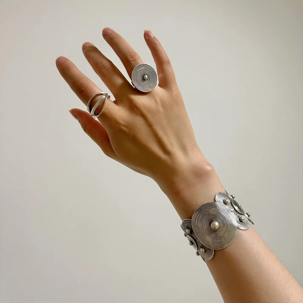 Hand mit kunstvollem Miao-Silberring und Armreif