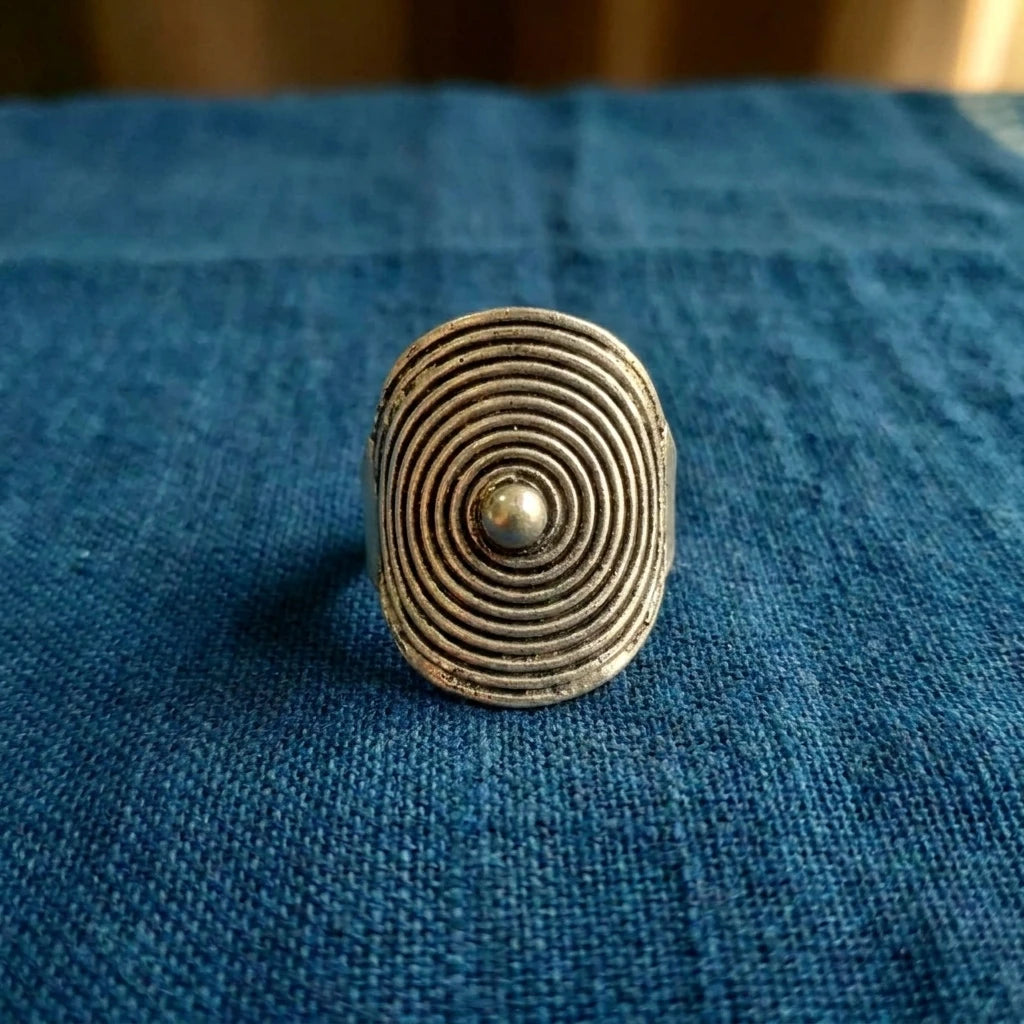 Miao Silver Round Disc Adjustable Ring displayed on indigo textile
