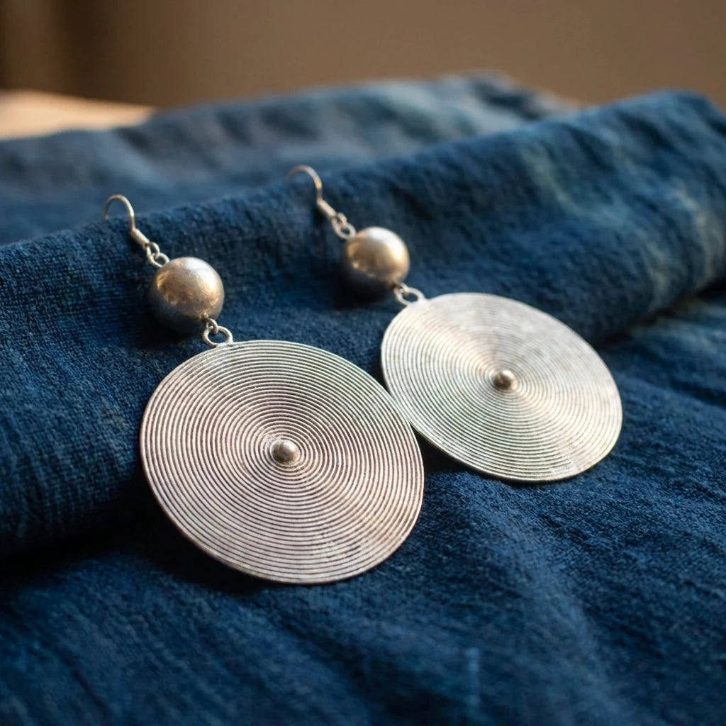 Miao Silver Round Disc Earrings – Large Disc displayed on indigo textile