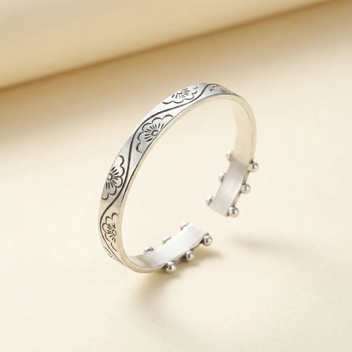 Miao Silver bracelet with floral patterns on a beige background