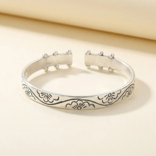 Miao Silver bracelet with floral engravings on a beige background