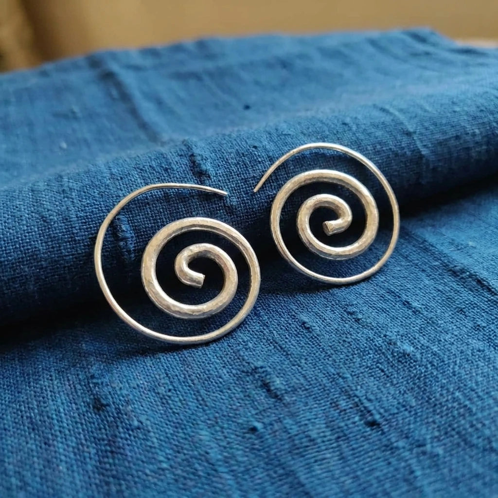 Miao Silver Spiral Stud Earrings displayed on indigo textile