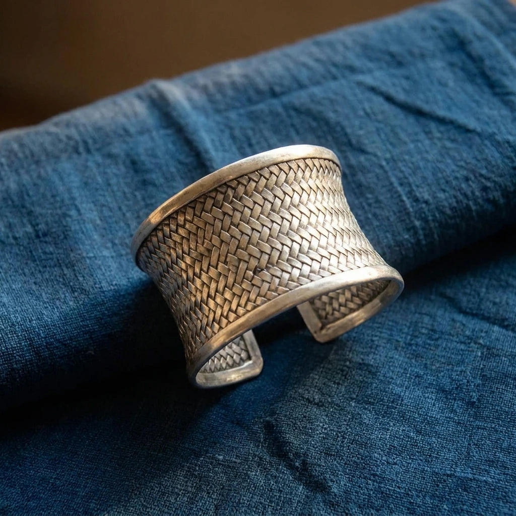 Miao Silver Woven Open Cuff Bracelet – 4 cm displayed on indigo textile