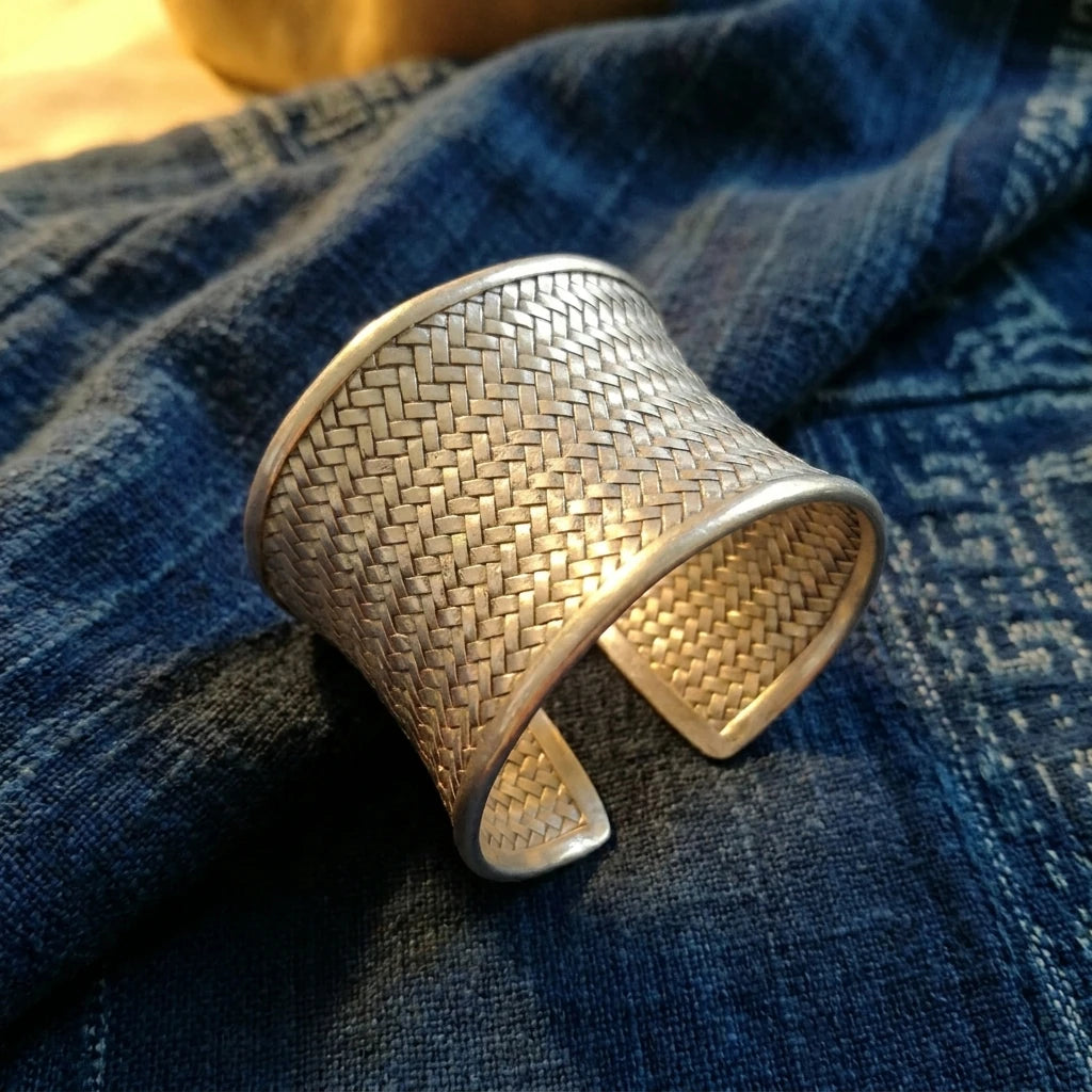 Miao Silver Woven Open Cuff Bracelet – 7.6 cm displayed on indigo textile